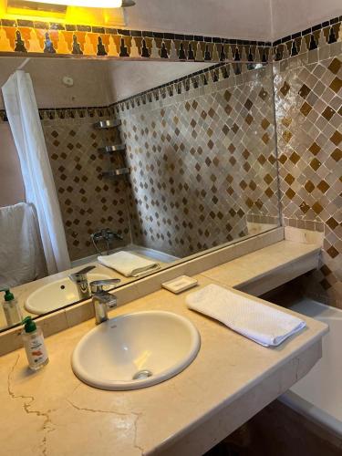 a bathroom counter with a sink and a mirror at Villa Aalama in Marrakech