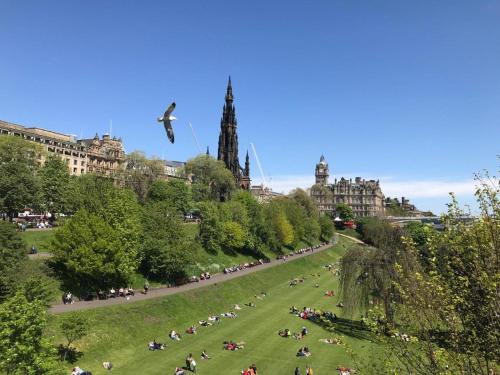 a group of people sitting in a field in a park at Three Bedrooms Flat in Central Edinburgh Old Town in Edinburgh
