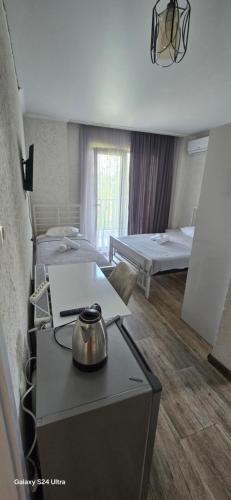 a room with two beds and a table with a tea kettle at ilios in K'obulet'i