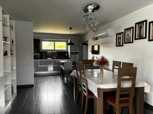 a kitchen and dining room with a table and chairs at Superbe villa 6 personnes proche océan et lac in Linxe