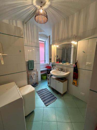 a bathroom with a sink and a toilet and a mirror at La casa rosa in Lingueglietta