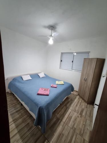 a bedroom with a bed with blue sheets and a cabinet at Casa Verde in Holambra