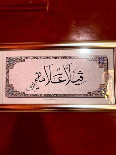 a sign with arabic writing in a gold frame at Villa Aalama in Marrakech