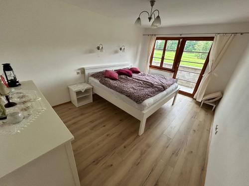 a bedroom with a bed with pink pillows on it at Nicole in Hartau