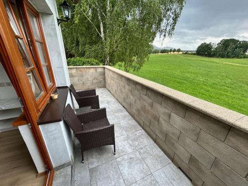a patio with two chairs and a stone wall at Nicole in Hartau