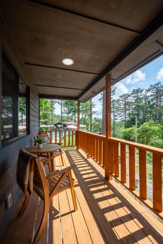 a porch with a wooden table and a table on it at The Woodsman Lodge in Eureka Springs