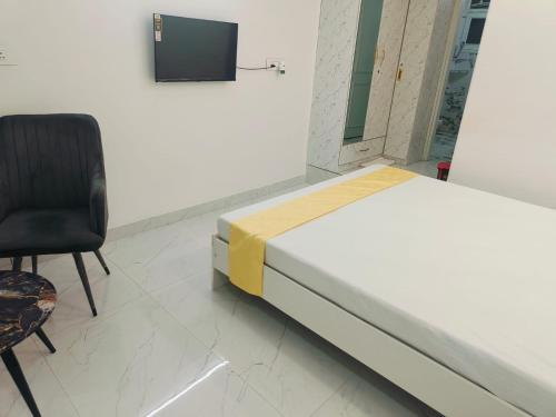 グルガオンにあるBancourt appartmentのベッド、椅子、テレビが備わる客室です。