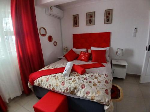 a bedroom with a large bed with red pillows at Orca Estate Guesthouse Self-catering Accommodation in Durban