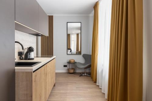 a kitchen with a sink and a desk with a chair at P6-A Riga Old Town Apartments in Rīga