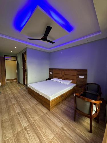 Schlafzimmer mit einem Bett und einer Decke mit blauen Lichtern in der Unterkunft J&B Royal Complex in Arki