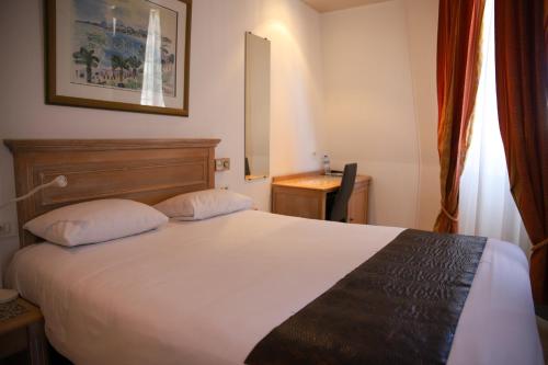 a hotel room with a bed and a desk at Brit Hotel Aux Sacres Reims, Centre Historique in Reims