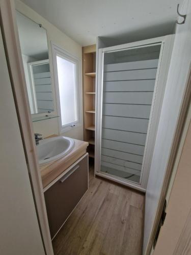 a bathroom with a sink and a mirror at Mobil home en Provence - Camping 4 étoiles- 2 chambres -4 à 6 pers-clim-terrasse-TV in Cadenet