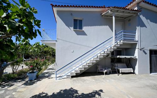 Casa blanca con escaleras y silla en Anchor Villa, en Troulos