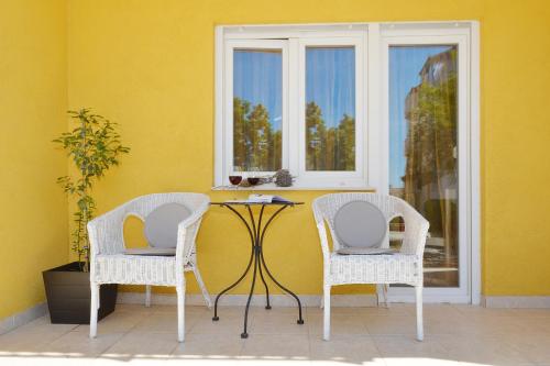 two chairs and a table in front of a window at Bora bora Apartment in Kaštela