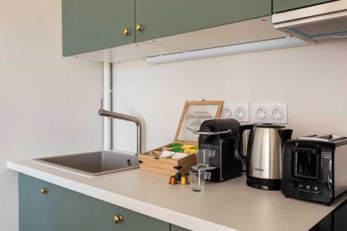 Una encimera de cocina con un fregadero y una cafetera. en Appartement Dify Deruelle - Part Dieu, en Lyon