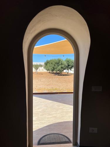 an archway with a view of a field through a window at Nausicaa Guesthouse in Marsala