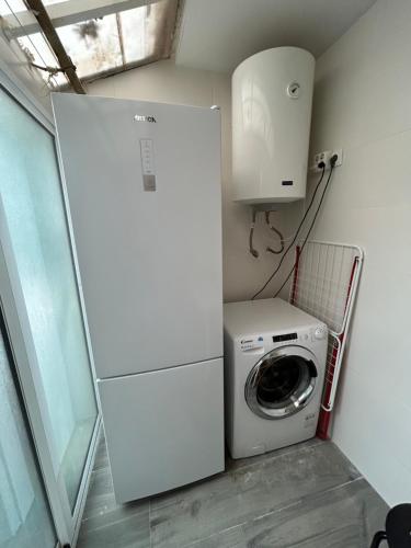 eine Waschmaschine und ein Trockner in einem kleinen Raum mit einem Kühlschrank in der Unterkunft Habitación privada en piso compartido cerca del Centro Alicante in Alicante