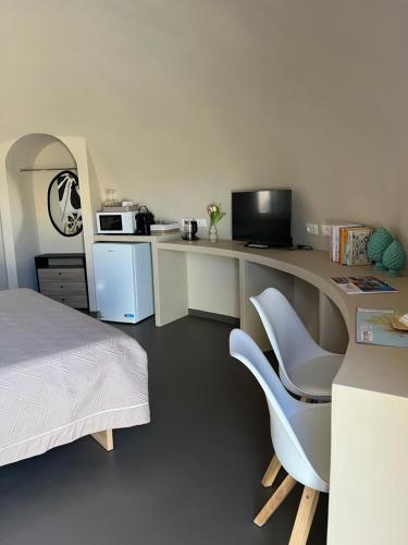 una camera con letto e scrivania con forno a microonde di Nausicaa Guesthouse a Marsala