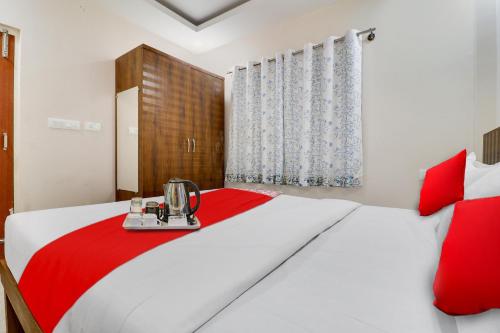 a bedroom with a white and red bed with a blender on it at Hotel O Mr Guestline in Bengaluru