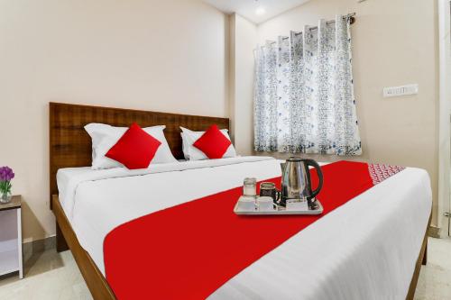 a bedroom with two beds with red and white sheets at Hotel O Mr Guestline in Bengaluru
