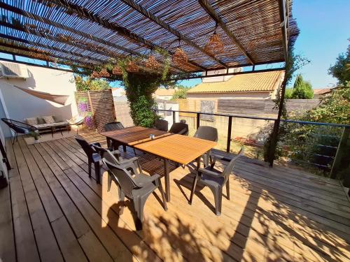 a wooden table and chairs on a wooden deck at Villa Evasion Soleil in Poussan