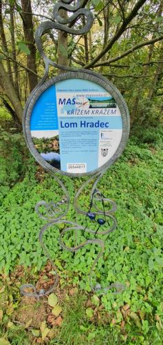 a sign that is sitting in the grass at Domek s koupanim ve 200m vzdálenem lomu in Hradec