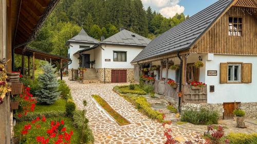 a house with a garden in front of a building at Locul cu Amintiri in Albac