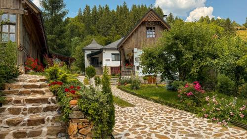 a stone path leading to a house with flowers at Locul cu Amintiri in Albac