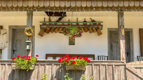 a house with two flower pots on a wooden fence at Locul cu Amintiri in Albac