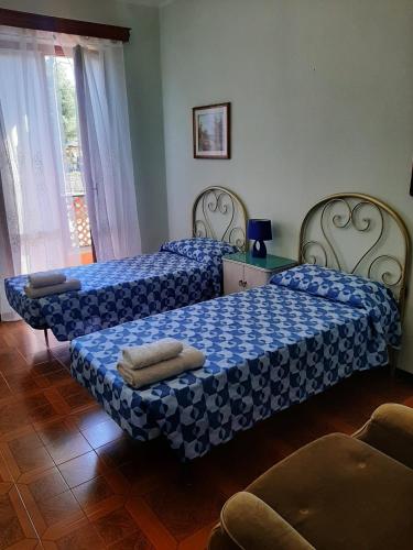 a bedroom with two beds with blue and white sheets at villamuna in Ferentillo