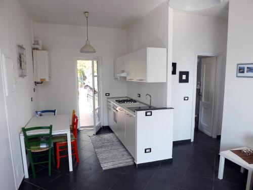 a kitchen with white cabinets and a table and a table sidx sidx at La Rimessa in Bonassola