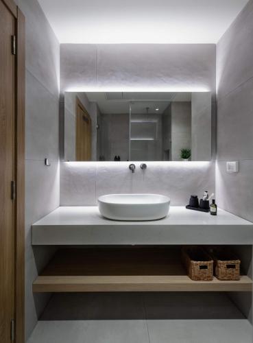 a bathroom with a sink and a mirror at Tayo Studios & Apartments in Bat Yam