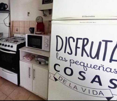 una cocina con nevera con un cartel. en Vista al Beagle, en Ushuaia