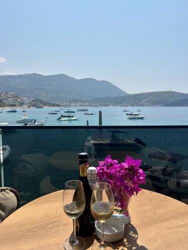 a table with two wine glasses and a vase of flowers at Rea Boutique Hotel in Himare