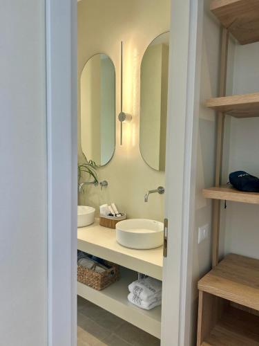 a bathroom with two sinks and two mirrors at Rea Boutique Hotel in Himare