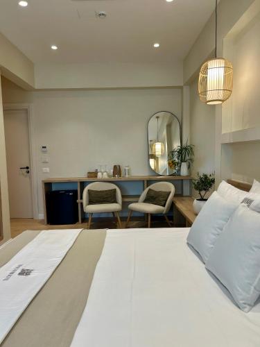 a bedroom with a large white bed and a mirror at Rea Boutique Hotel in Himare