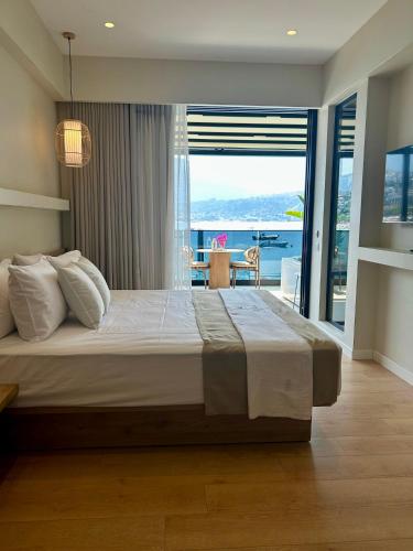 a bedroom with a large bed with a view of the ocean at Rea Boutique Hotel in Himare