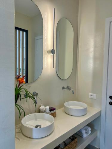 a bathroom with two sinks and a mirror at Rea Boutique Hotel in Himare