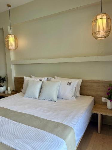 a large bed with white sheets and pillows at Rea Boutique Hotel in Himare
