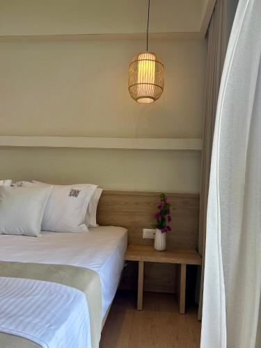 a bedroom with two beds and a potted plant on a table at Rea Boutique Hotel in Himare