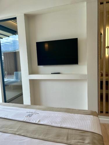 a living room with a flat screen tv on a wall at Rea Boutique Hotel in Himare