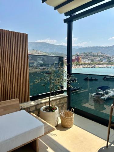a balcony with a table and a view of a harbor at Rea Boutique Hotel in Himare