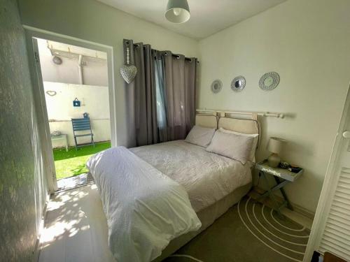 a bedroom with a bed and a large window at Beachfront Studio Flat in Cape Town