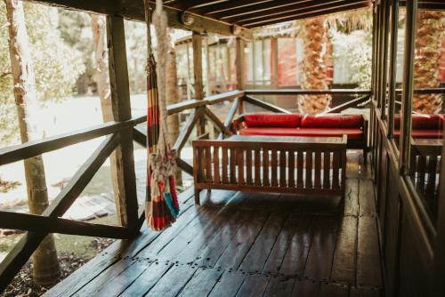 a porch with two red benches on a wooden floor at Complejo Aramis Chapadmalal in Chapadmalal