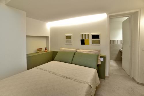 Un dormitorio con una cama con cabecero verde. en Auditorium Rooms, en Foligno