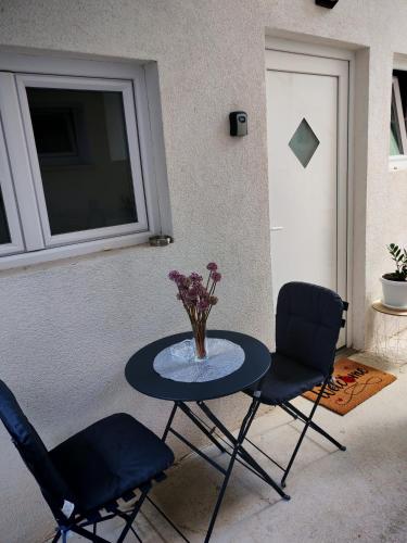 a table with two chairs and a vase of flowers on it at Lukas in Makarska