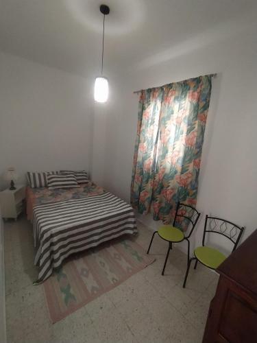 a bedroom with two beds and a table and chairs at zouila home in Mahdia