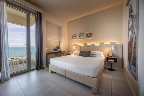 a bedroom with a large bed with a view of the ocean at Nautilus Family Hotel in Pesaro