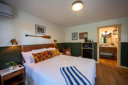a bedroom with a large bed and a bathroom at The Woodsman Lodge in Eureka Springs