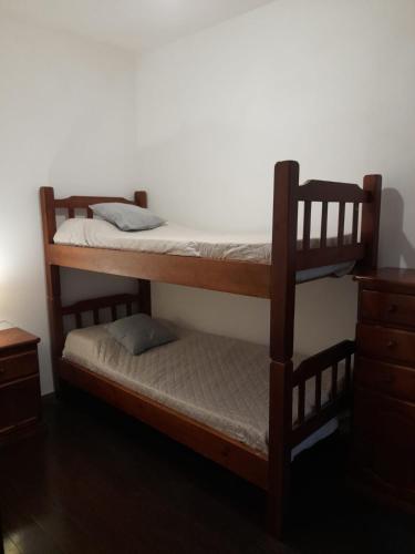 a bedroom with two bunk beds and a dresser at Casa Calma in Colonia del Sacramento